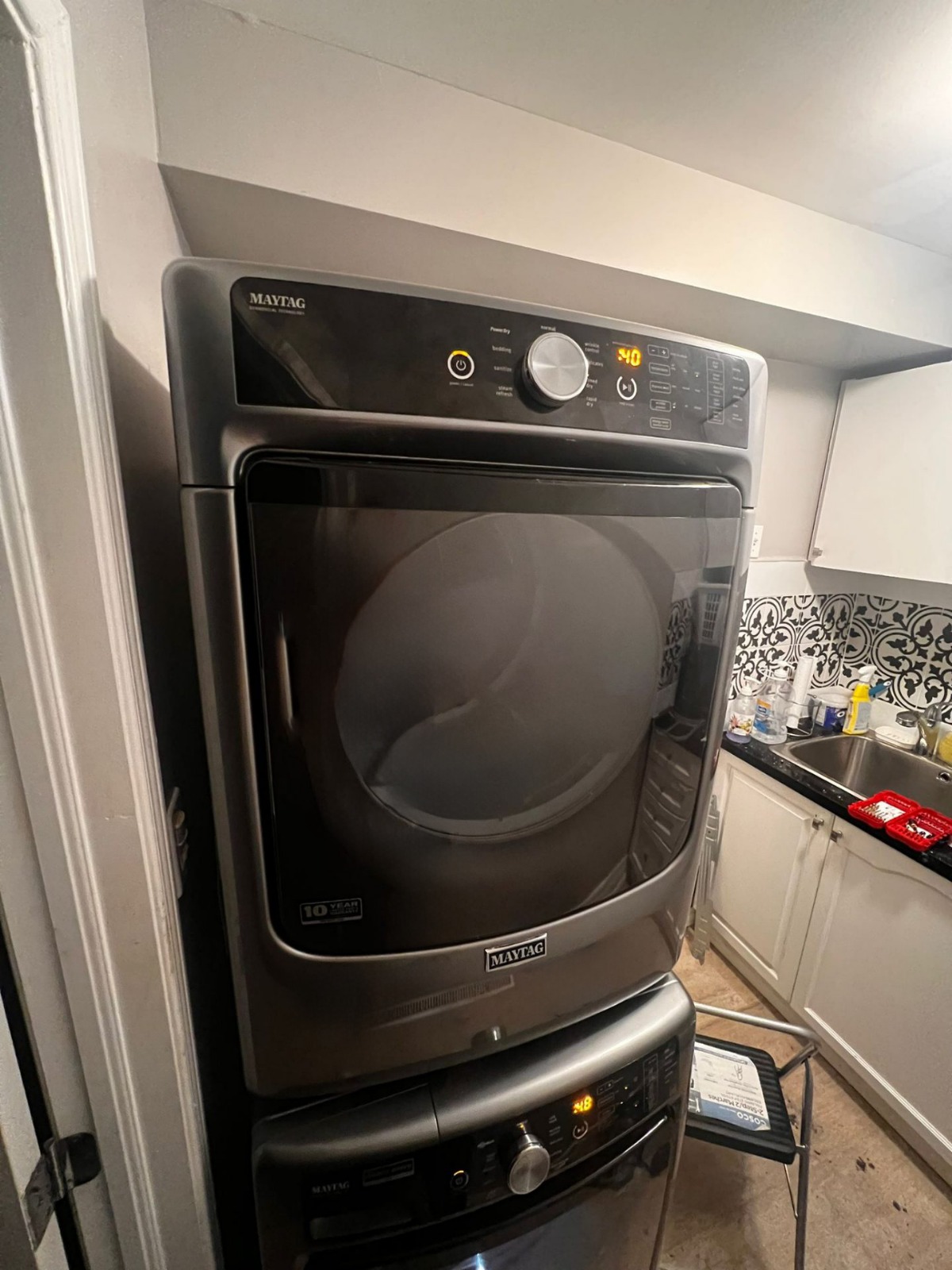 Professional appliance repair technician working on a modern Maytag dryer